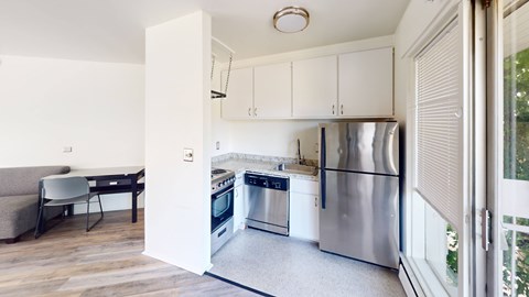 A kitchen with stainless steel appliances and white cabinets.